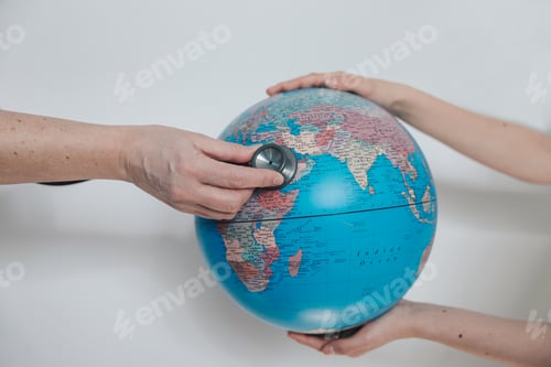 Preview: Girl holds planet earth globe and woman explores with stethoscope