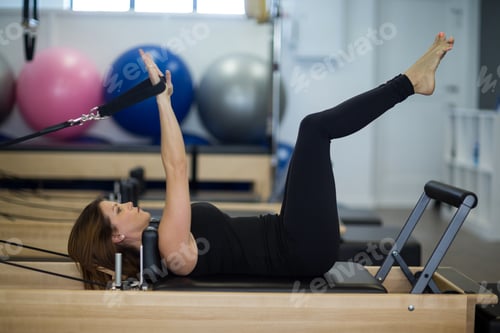 Preview: Woman practicing stretching exercise on reformer