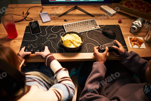 Preview: Teenage Girl and Black Teenage Boy Playing Video Game Together Indoors