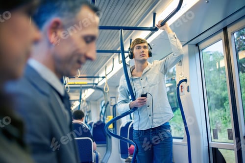 Preview: Young man on train listening to headphones