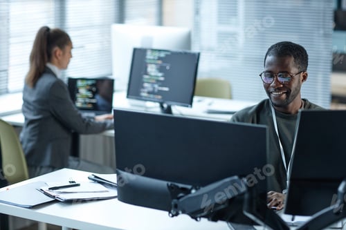 Preview: Smiling Black Man Using Computers at Workplace in Office