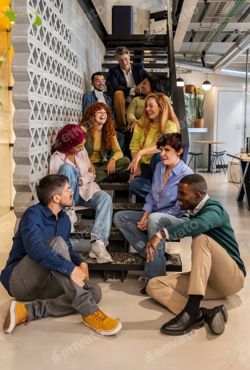 Preview: Coworkers having fun chatting and laughing sitting on office stairs during a break