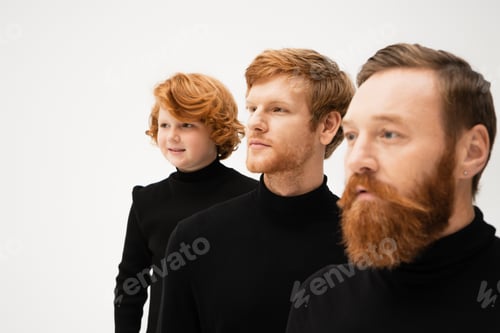 Preview: smiling redhead boy in black sweater looking away near father and bearded grandpa on blurred