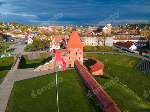 Preview: Kauna castle made of red brick red flag in front with a cloudy sky on the horizon, Lithuania