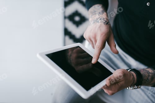 Preview: cropped shot of businessman with tattoos using digital tablet with blank screen