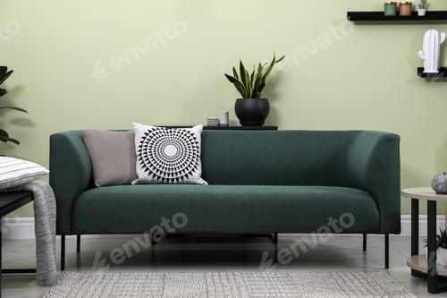Preview: Stylish living room interior with comfortable green sofa and beautiful plants