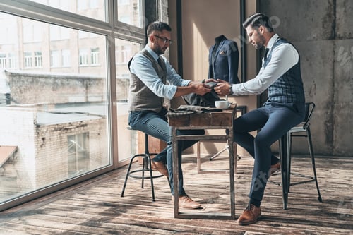 Preview: Two Men Examining Fabric Samples in a Tailor Shop