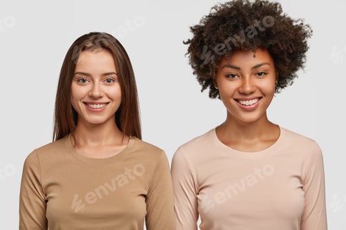 Preview: People, diversity and friendship concept. Two happy mixed race beautiful females smile positively at