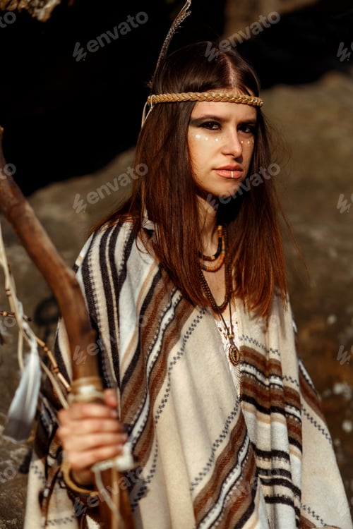 Preview: beautiful native indian american woman with warrior shaman make up on background of rocks