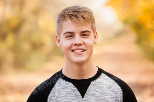 Preview: Head and shoulder portrait of teenage boy in autumn forest