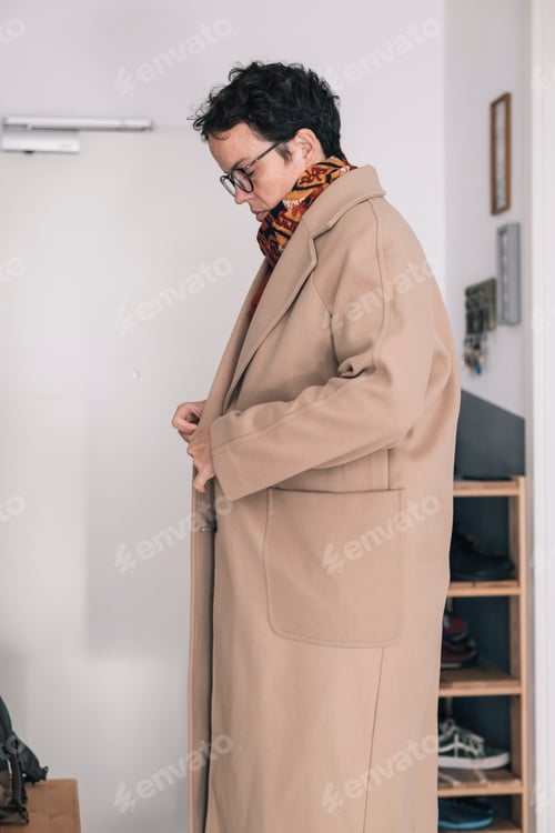 Preview: Stylish freelancer buttoning elegant camel coat before going to work