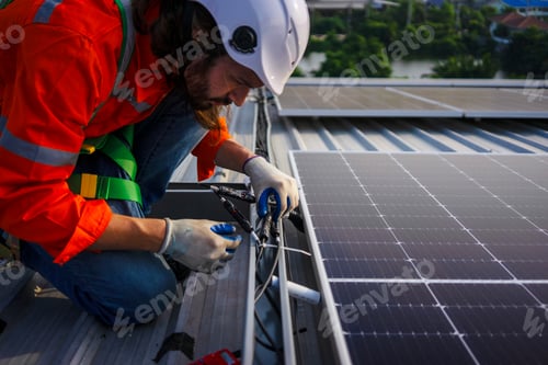 Preview: Blue collar worker is inspecting solar panel at rooftop of factory.