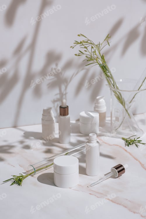 Preview: Cosmetic products in white packaging, laboratory glassware. Science skincare concept