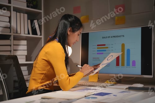 Preview: Businesswoman working late in her office, illuminated by the glow of her computer screen