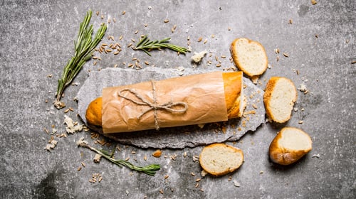 Preview: Fresh ciabatta with rosemary on a stone stand.