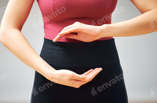 Preview: Shot of a woman forming a circle with her hands in front of her belly