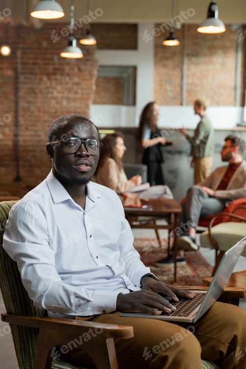 Preview: Young businessman working in the net while his colleagues discussing working points