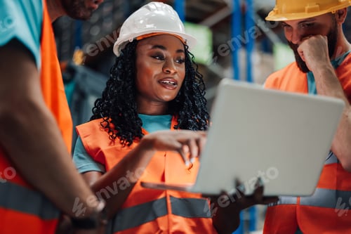 Preview: Warehouse workers having discussion using laptop computer