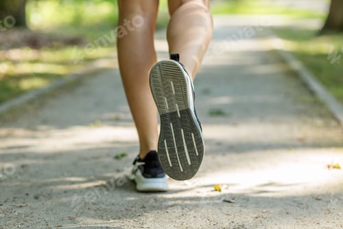 Preview: Close-up of running shoe in motion on park trail. Body care.