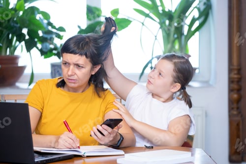Preview: Mother working from home with kid. Children make noise and disturb woman at work.