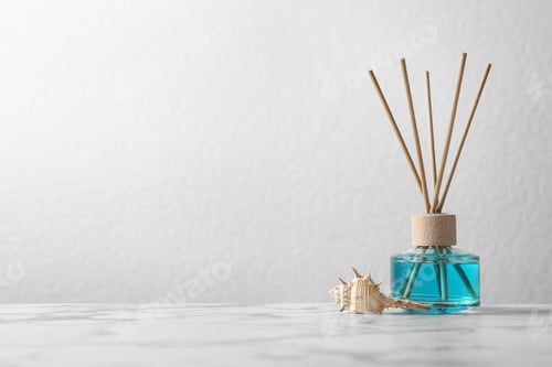 Preview: Aromatic reed freshener and sea shell on marble table against light background, space for text