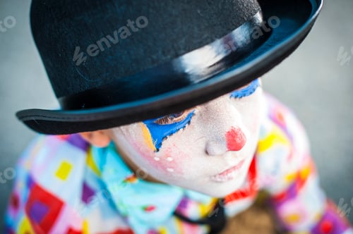 Vista previa: alone boy 8/6 years old with clown makeup - sad wearing hat