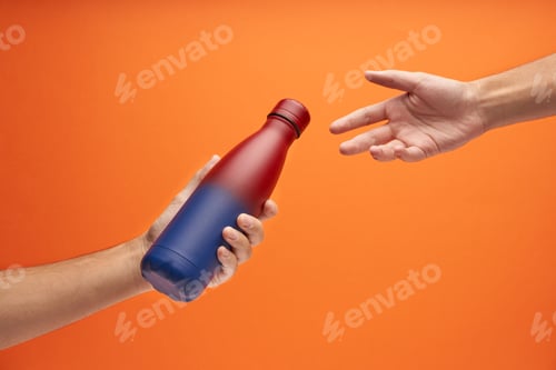 Preview: Close-up of male hands, sharing a red and blue gradient reusable steel eco thermo water bottle.