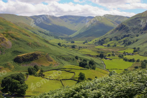 Preview: Lush green valley with a patchwork of rolling hills and lush grassy fields.
