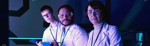 Preview: banner, Three Scientists Engage in Headshot Analysis Within Neon-Lit Science Center.