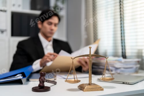 Preview: Asian lawyer working with gavel and scales of justice in courtroom office.