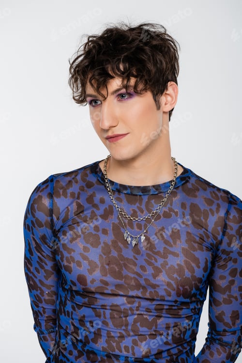 Preview: brunette queer model in long sleeve shirt and silver necklaces isolated on grey