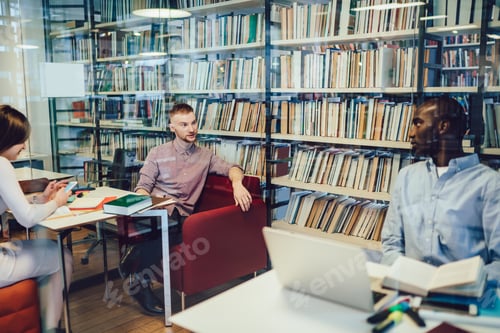 Preview: Male students talking during break in library