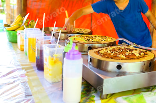 Preview: Woman cooking traditinal Thai Banana Pancake with chocolate