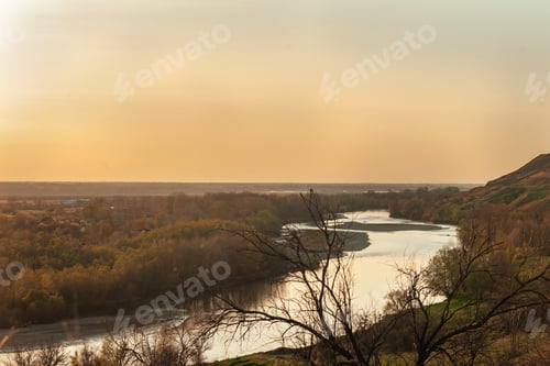 Preview: nature in early spring at sunset, the river and the village below