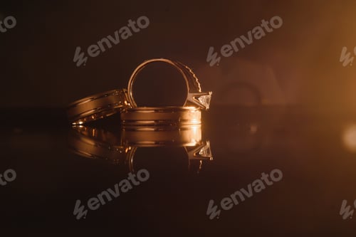 Preview: Elegant wedding rings for the bride and groom on a black background with highlights