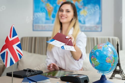 Preview: Portrait of a travel agent in a travel agency with passports and tickets