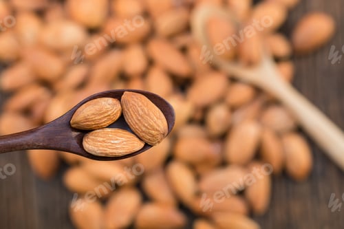Preview: Almonds nut on the wooden spoon and wooden table.