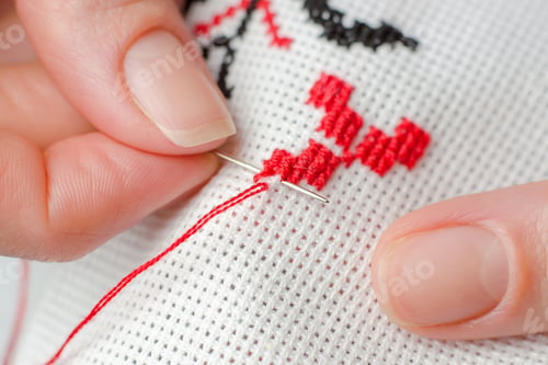 Preview: A woman embroiders the national symbols of Ukraine with a cross. Female hands cross-stitching