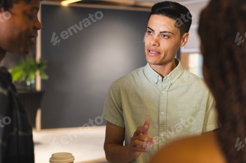 Preview: Diverse group of colleagues talking in a modern business office, biracial man in focus
