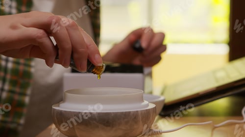 Preview: Woman adds essential oil into diffuser