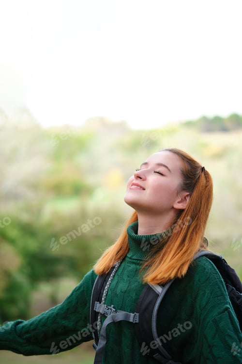 Preview: Female hiker breathing fresh air in the mountain.