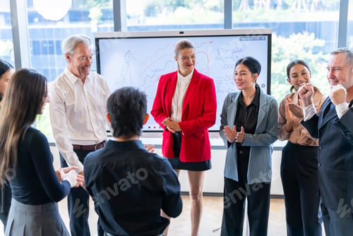 Preview: Diverse business team celebrating success in a modern office meeting with a whiteboard presentation