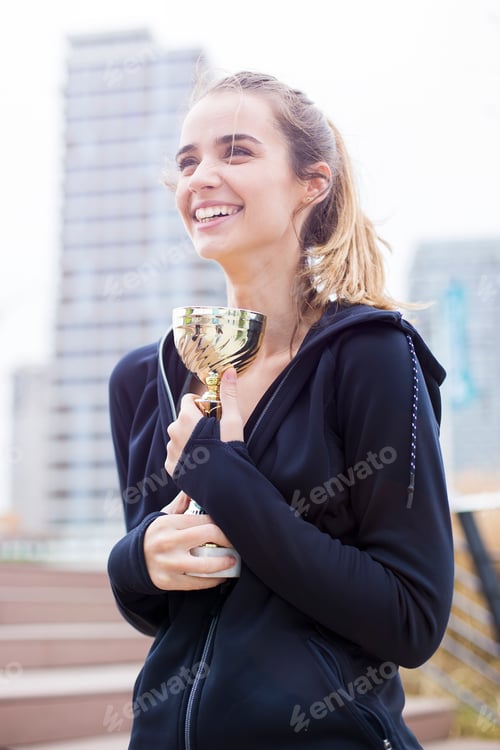 Preview: Sport woman holding a trophy