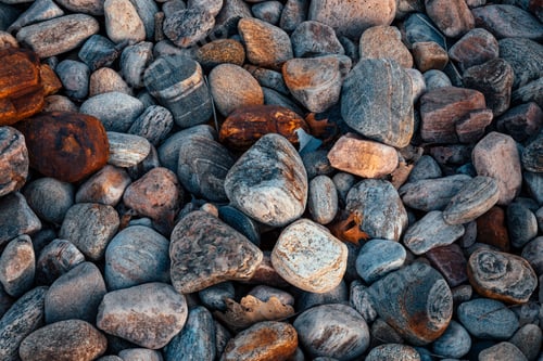 Preview: Close-up view of a variety of colored pebbles scattered across the surface, each of varying sizes