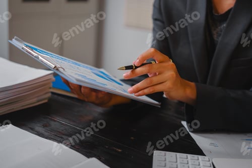 Preview: A businessman works late at his desk, focused on his laptop while talking online.checks important