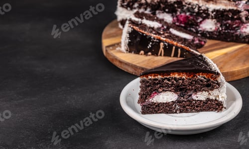 Preview: Chocolate cake slice on plate with whole cake on wooden board