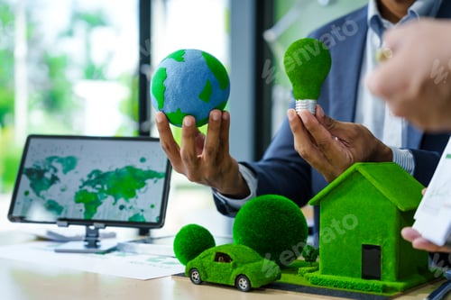 Preview: A meeting at an office desk focuses on teamwork with a house model and discussions on electric cars