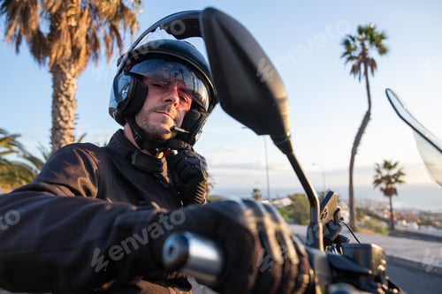 Preview: A motorcyclist puts on his helmet before setting off on a road trip on his motorcycle