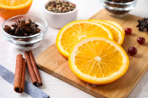 Preview: Cut orange, cinnamon sticks and cranberries on table. Mulled wine ingredients