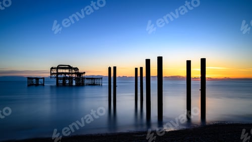 Preview: Pier poles at sunset near a fishing dock, extending into the ocean